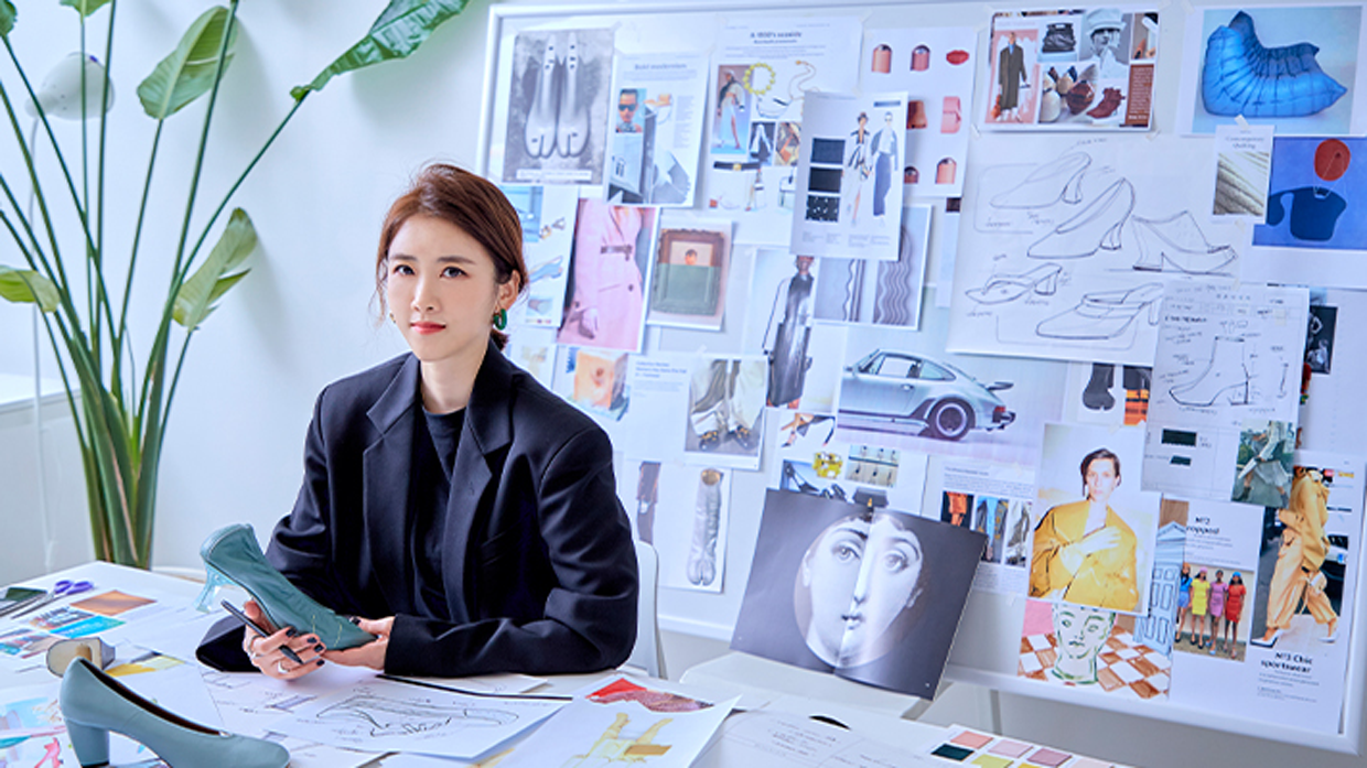 작업 테이블에 앉아 카메라를 응시하는 이민아 모습