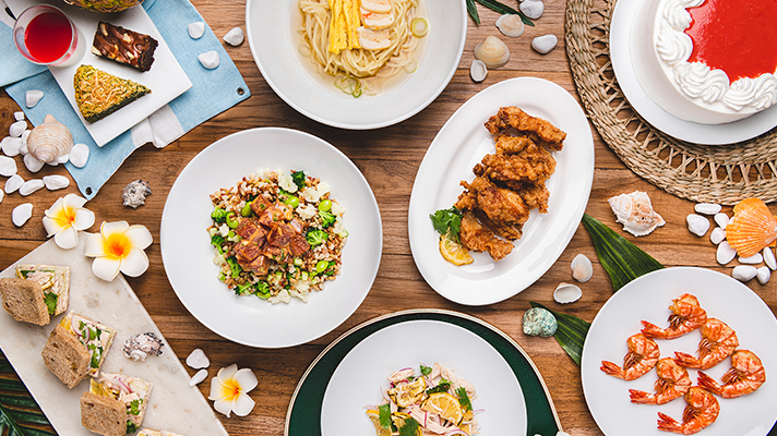 원목 테이블 위에 다양한 하와이 로컬 음식이 놓여진 모습