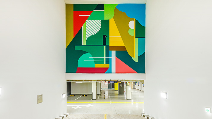 지하 주차장을 내려갈 때 정면에 보이는 벽에 정크하우스 작가와 협업한 색색의 아트월이 설치돼 있다