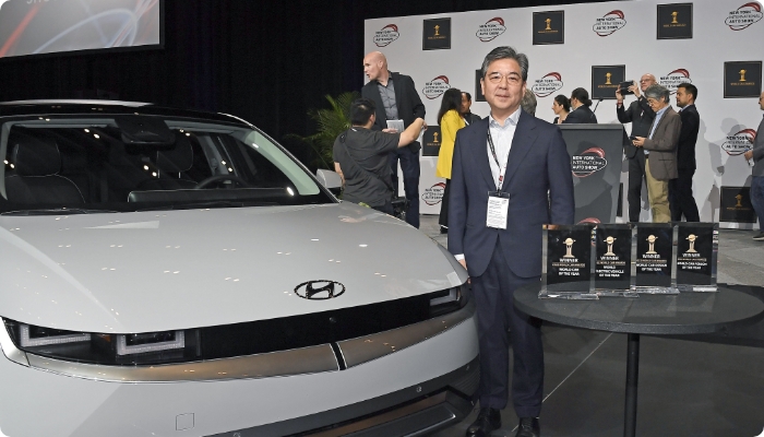 세계 올해의 자동차를 수상한 아이오닉 5와 장재훈 현대차 대표이사의 모습