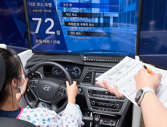 가상운전 시뮬레이터에서 한 여성이 운전 재활 프로그램을 수행하고 있다