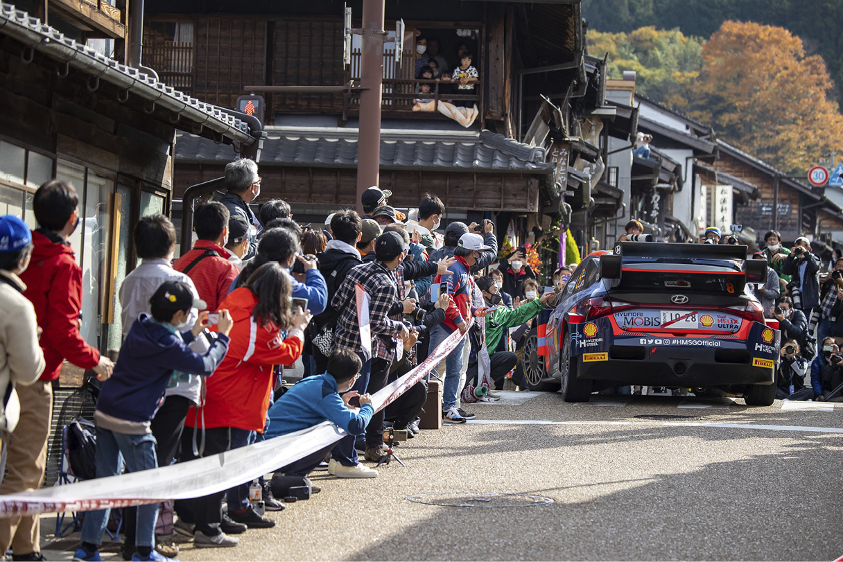 관중들의 환호를 받으며 서있는 WRC 경주차의 모습