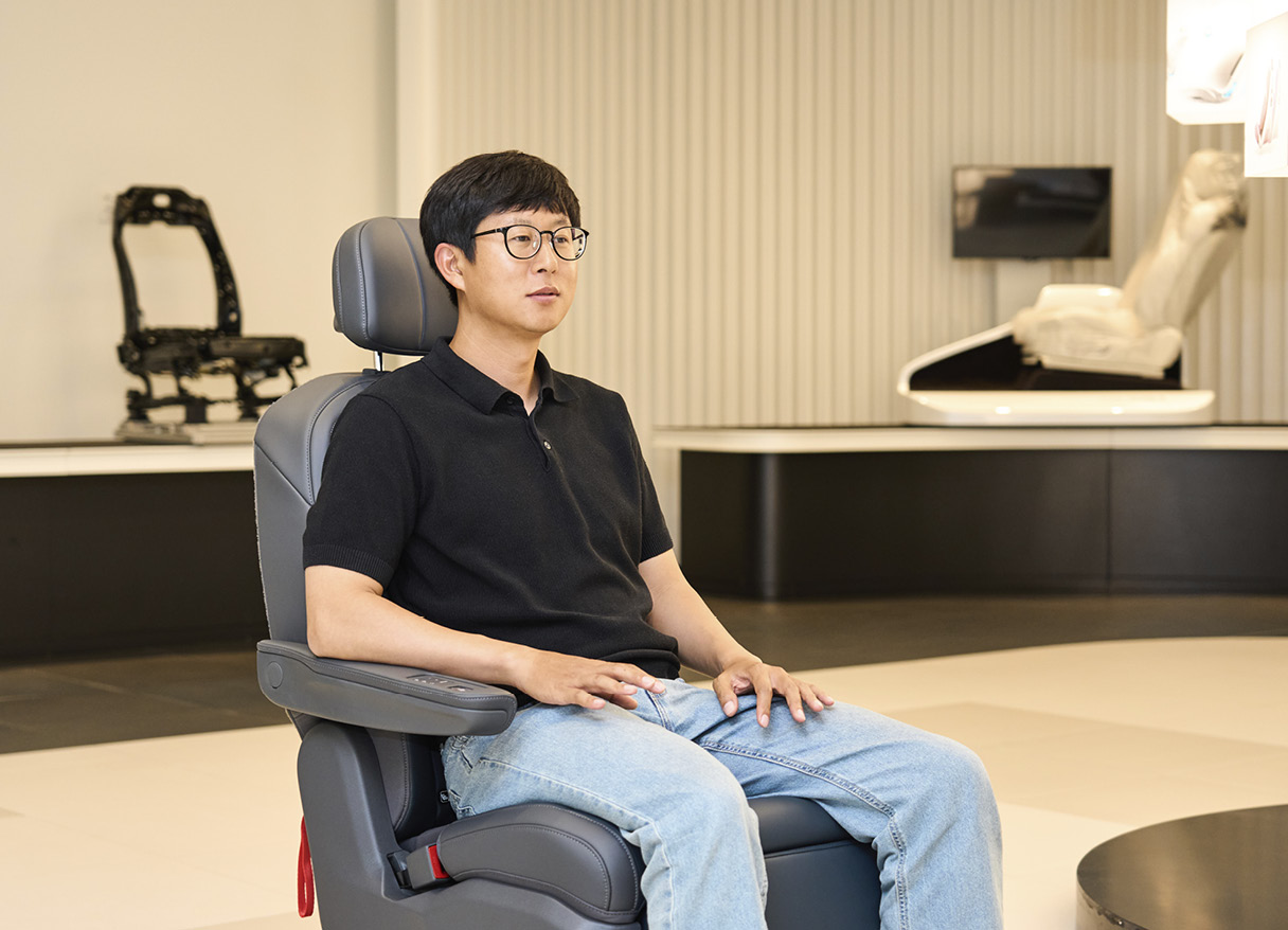 송현석 책임연구원이 시트에 앉아 기능에 대해 설명하고 있다