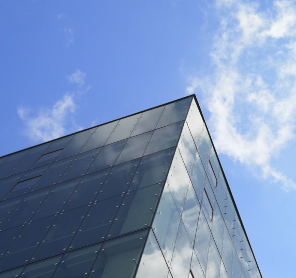 HMGICS 건물의 측면 모서리와 구름 있는 하늘을 함께 촬영한 모습