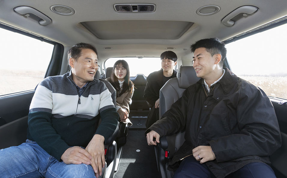 기아 더 뉴 카니발 하이브리드의 실내에서 이야기를 나누는 담당 연구원들의 모습