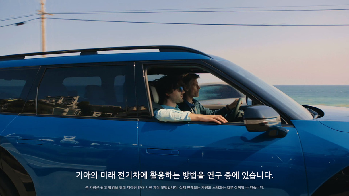 차로 이동하며 이야기를 나누는 두 남자