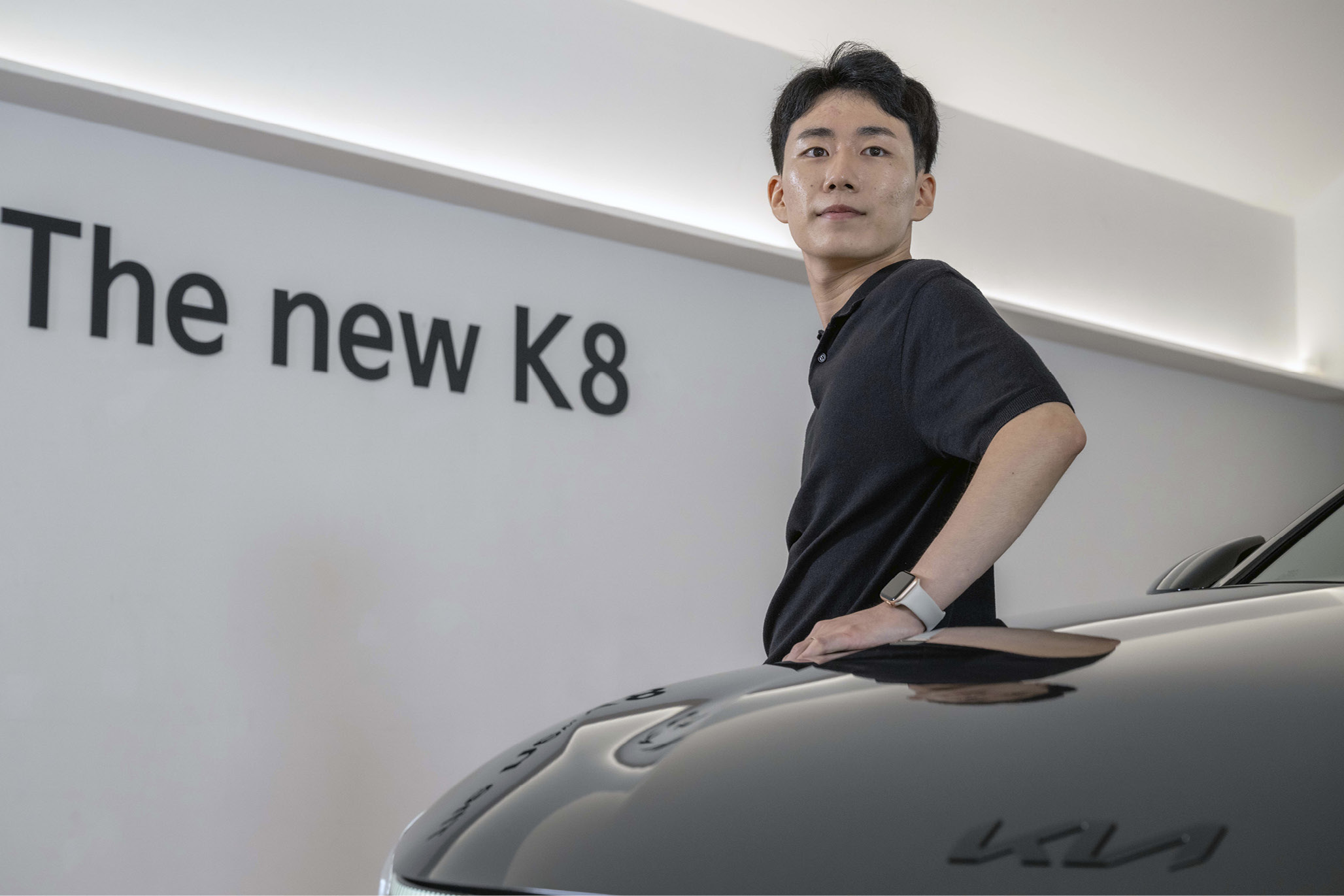남성이 자동차 보닛 옆에 포즈를 취한 모습