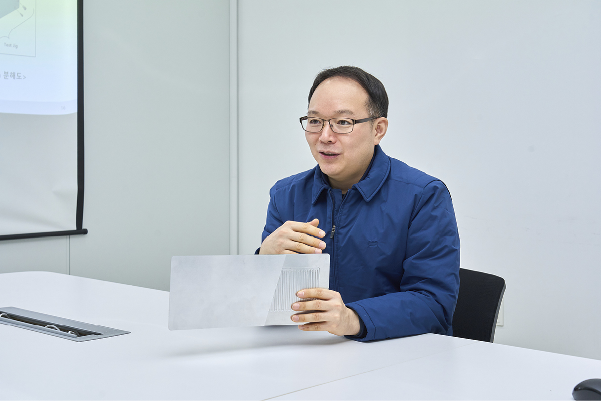 진동형 히트파이프를 손에 들고 설명하는 남성 연구원